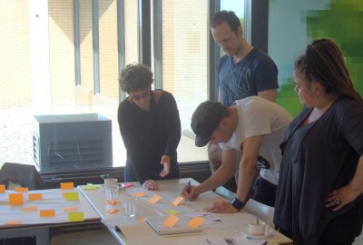 Vier deelnemers van een workshop buigen zich over een opdracht.